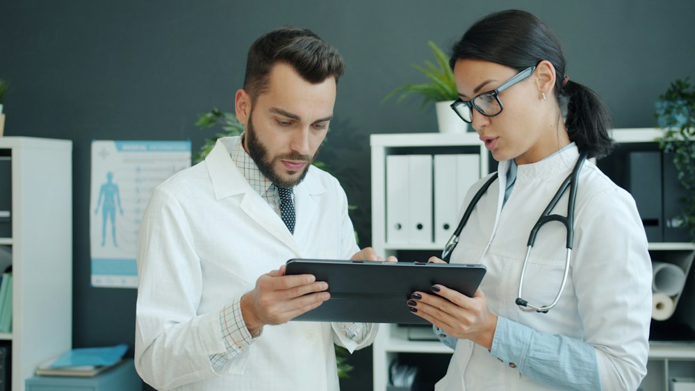 Imagen ilustrativa de profesionales de salud consultando una tableta