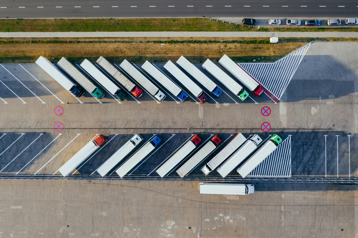 Vista aérea de camiones en un centro logístico de supply chain